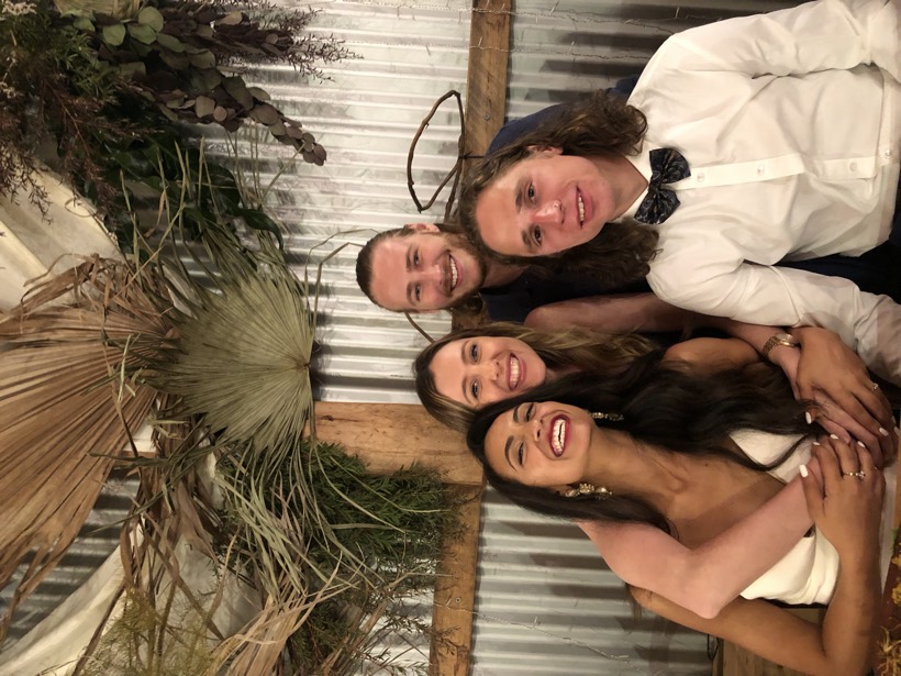 Brittany and Deklan smiling closely with loved ones at a celebration.