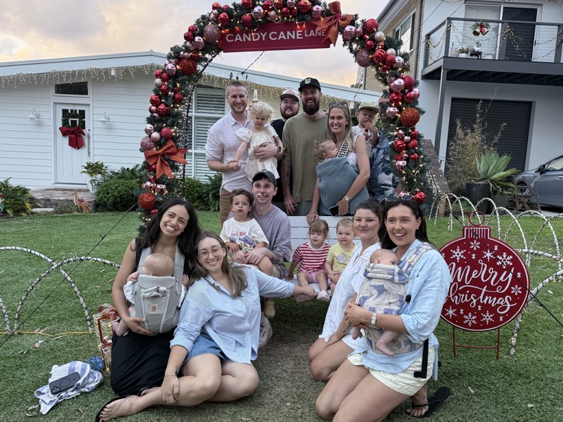 Family and friends gathered under a Christmas arch.