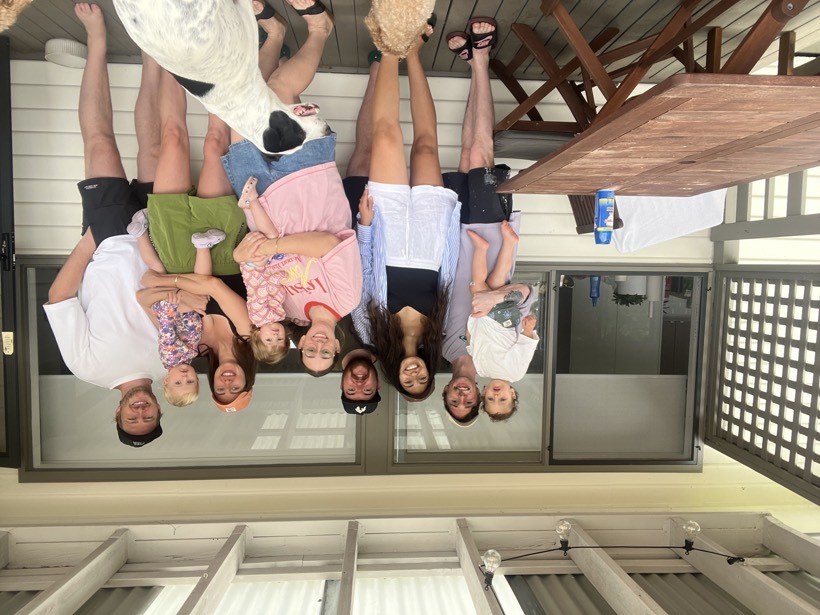 Brittany and loved ones gathered on a sunny deck with children and dogs.