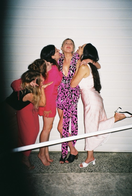 Friends surrounding Brittany with hugs and kisses in a playful photo.