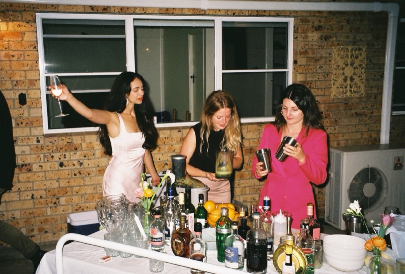 Friends mixing drinks together at a home celebration.