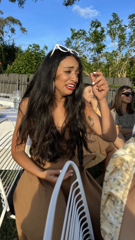 Brittany laughing outside in warm sunlight.