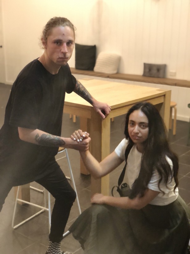 Brittany and Deklan holding hands in a quiet indoor photo.